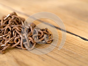 Rusty old steel chain put on a wooden table. photo