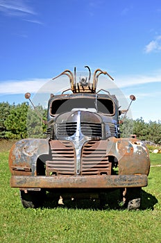 Rusty old truck with sculpture on cab