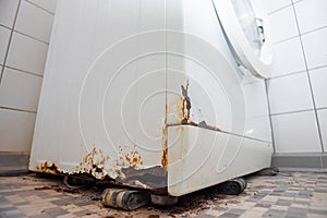 Rusty old washing machine in a bathroom - broken corner - wide angle