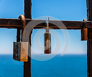 Rusty padlock attached to a balustrade by the sea, a traditional