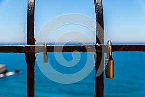 Rusty padlock attached to a balustrade by the sea, a traditional