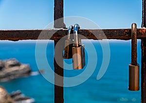Rusty padlock attached to a balustrade by the sea, a traditional