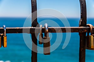 Rusty padlock attached to a balustrade by the sea, a traditional