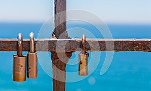 Rusty padlock attached to a balustrade by the sea, a traditional