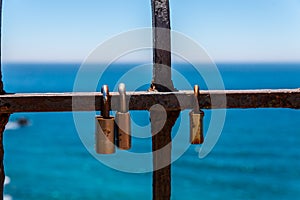 Rusty padlock attached to a balustrade by the sea, a traditional