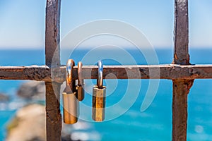 Rusty padlock attached to a balustrade by the sea, a traditional