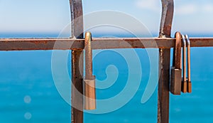 Rusty padlock attached to a balustrade by the sea, a traditional