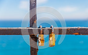 Rusty padlock attached to a balustrade by the sea, a traditional