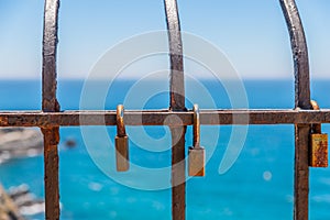 Rusty padlock attached to a balustrade by the sea, a traditional