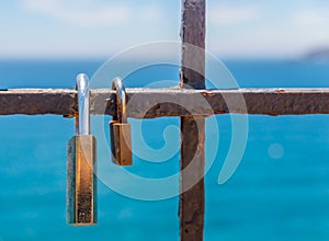 Rusty padlock attached to a balustrade by the sea, a traditional