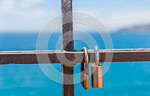 Rusty padlock attached to a balustrade by the sea, a traditional