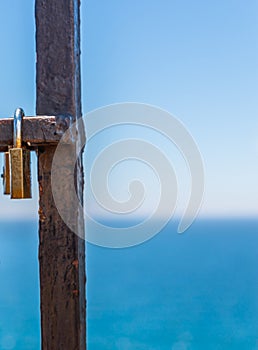 Rusty padlock attached to a balustrade by the sea, a traditional