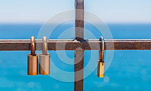 Rusty padlock attached to a balustrade by the sea, a traditional