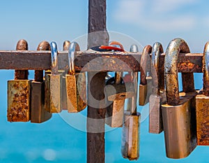 Rusty padlock attached to a balustrade by the sea, a traditional