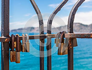 Rusty padlock attached to a balustrade by the sea, a traditional