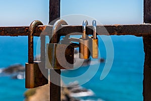 Rusty padlock attached to a balustrade by the sea, a traditional