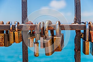 Rusty padlock attached to a balustrade by the sea, a traditional