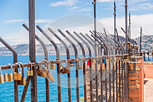 Rusty padlock attached to a balustrade by the sea, a traditional