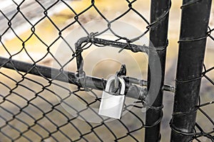 Rusty Padlock Attached to Caged Fence