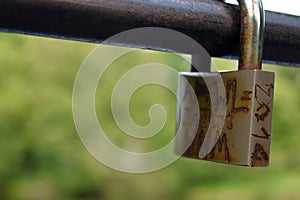 A rusty padlock on the bridge railing