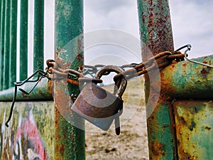 Rusty Padlock on the gate in the meadow fence.