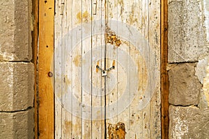 Rusty padlock locking old wooden door with a chain