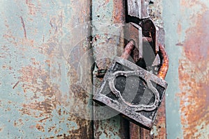 Rusty padlock locks the old gate of an abandoned hangar