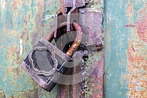 Rusty padlock locks the old gate of an abandoned hangar