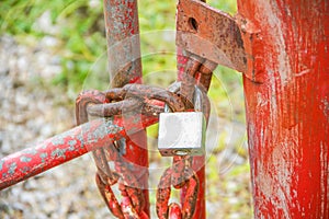 Rusty padlock metal with chian on old red steel fence