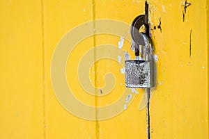 rusty padlock on vintage yellow door