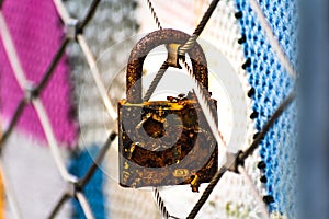 Rusty padlocks attached to the metal railing of a bridge, tradition of padlocks, symbol of eternal love