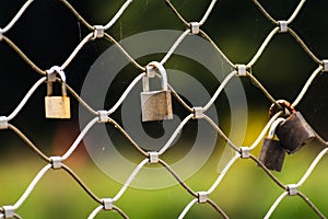 Rusty padlocks attached to the metal railing of a bridge, tradition of padlocks, symbol of eternal love