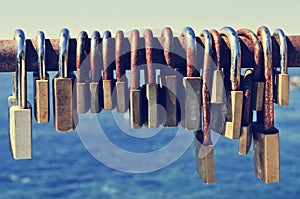 Rusty padlocks on a railing near the sea