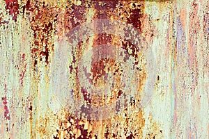 Rusty painted metal texture. Old iron background painted in yellow with rust. Weathered metal wall surface with cracked paint