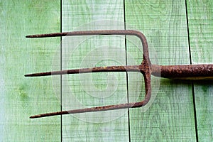 Rusty pitchfork on wooden planks photo
