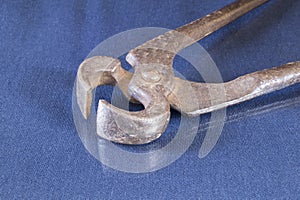 Rusty pliers lie on a table with a reflection