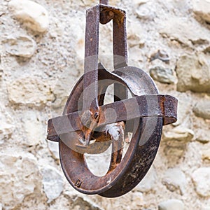 Rusty pull chain attached to an aged stone wall in an outdoor setting