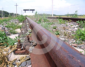 Rusty rails of a dead end rail road overgrown unused