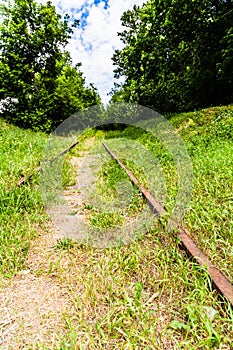 rusty rails and wooden sleepers in green grass