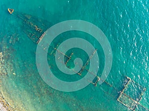 The rusty remains of the old sea dry cargo ship on the shallow water