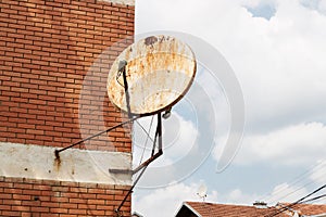 Rusty satellite dish on the outside wall