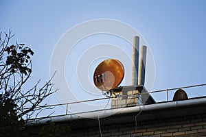 Rusty satellite dish on the roof of the house