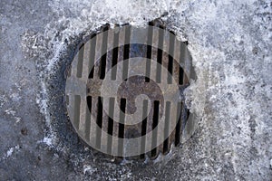 Rusty sewer in ice on top