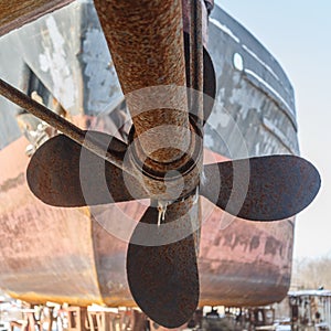 Rusty and shaft against the hull of the ship, standing on the shore in anticipation of repair