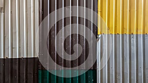 Rusty sheets of corrugated iron in different colors. Texture background of brown, gray, yellow, green corrugated fence. Colorful