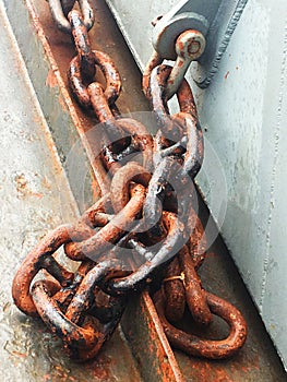 Rusty ship chain on the stone coast