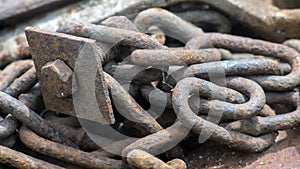 Rusty ship chain on the stone coast. Close up.