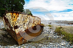 Rusty ship stranded aground on the beach with pebbles in the Black Sea