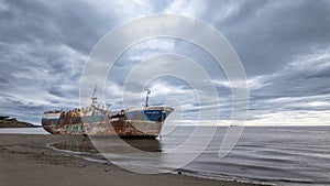 Rusty Shipwreck on Shore with Swift Clouds in Timelapse