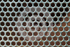 Rusty silver metal background with round holes